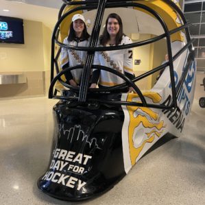 Jess and Kara standing inside a giant hockey mask.