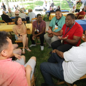 Group of alumni talking in a circle under the beer garden tent. Photo by Ed Mailliard.