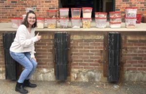 Student poses with containers of food recovered from dining hall.