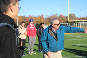 Allegheny Head Football Coach Rich Nagy explains some football nuances to visiting economics students.