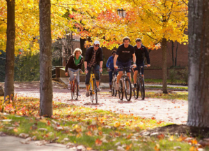 Students biking on campus on an autumn day