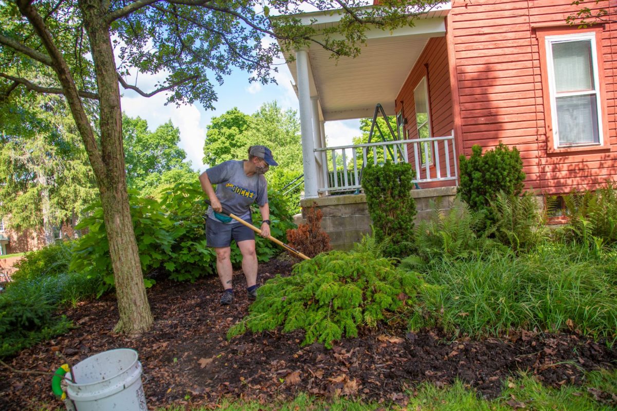 Tiffany Hrach rakes the garden outside the Prayer and Meditation House at Allegheny College. (Photos by Derek Li)