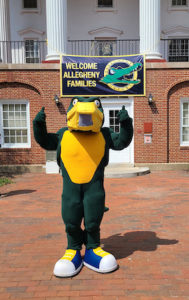 Chompers, Allegheny College's mascot standing front of a banner reading "Welcome, Allegheny families"