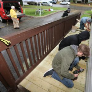 Students drill wood on a porch during Make a Difference Day