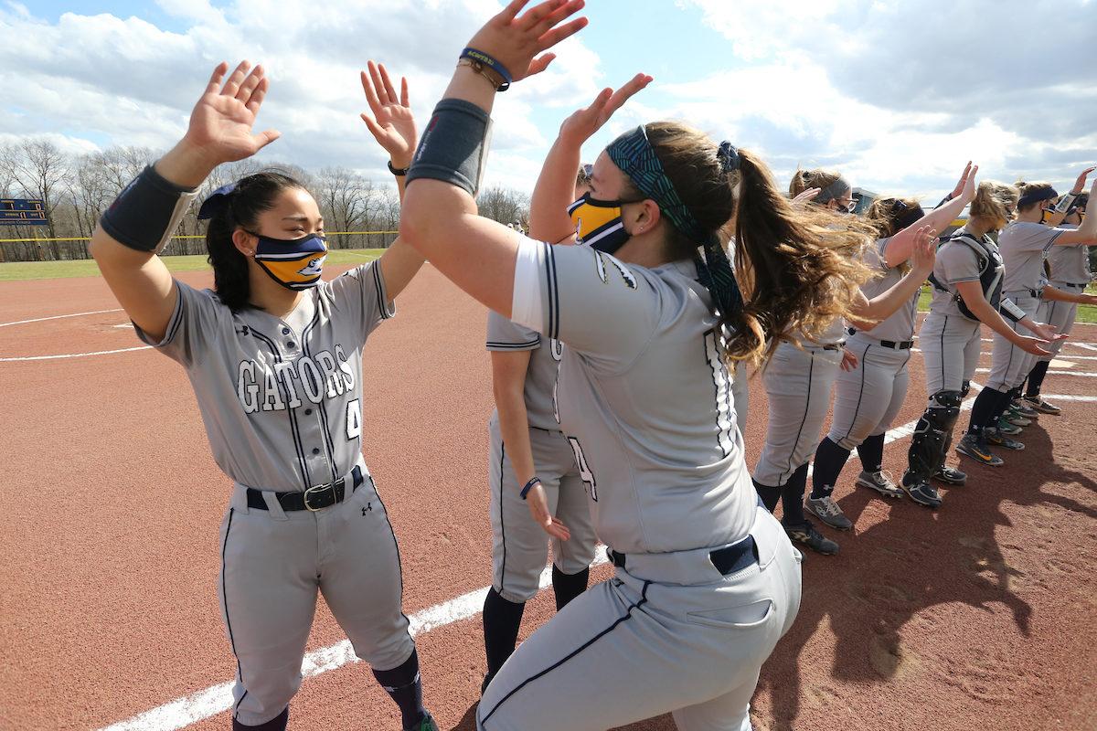 A line of softball players high fiving