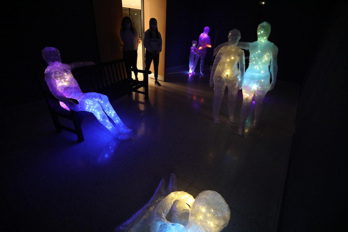 glowing human figure artwork in a dark room