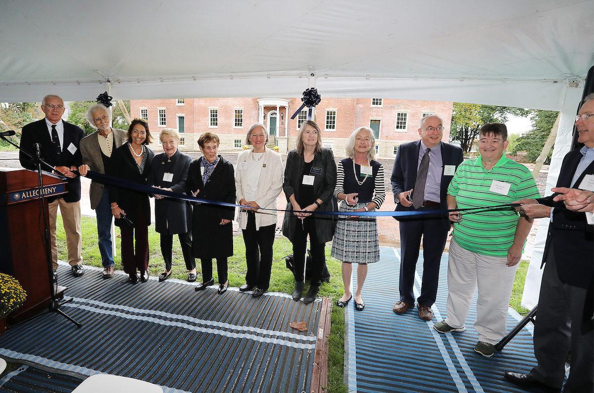 people prepare to cut a ribbon at the Bentley Hall rededication ceremony