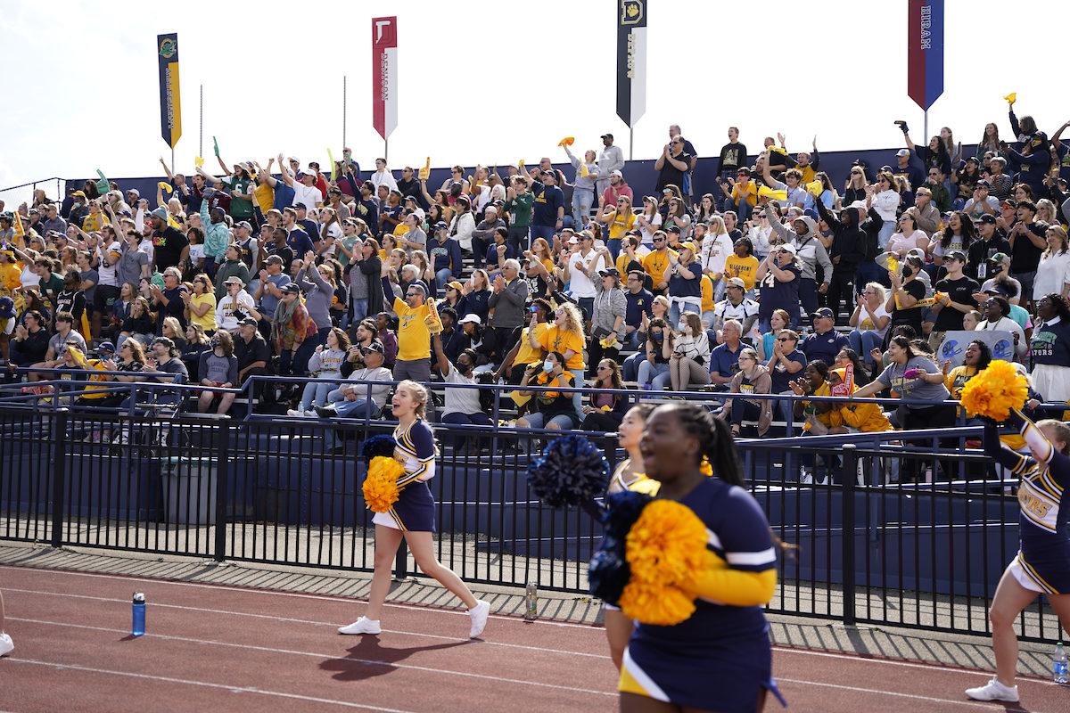 Cheerleaders in front of a cheering crowd at a football game
