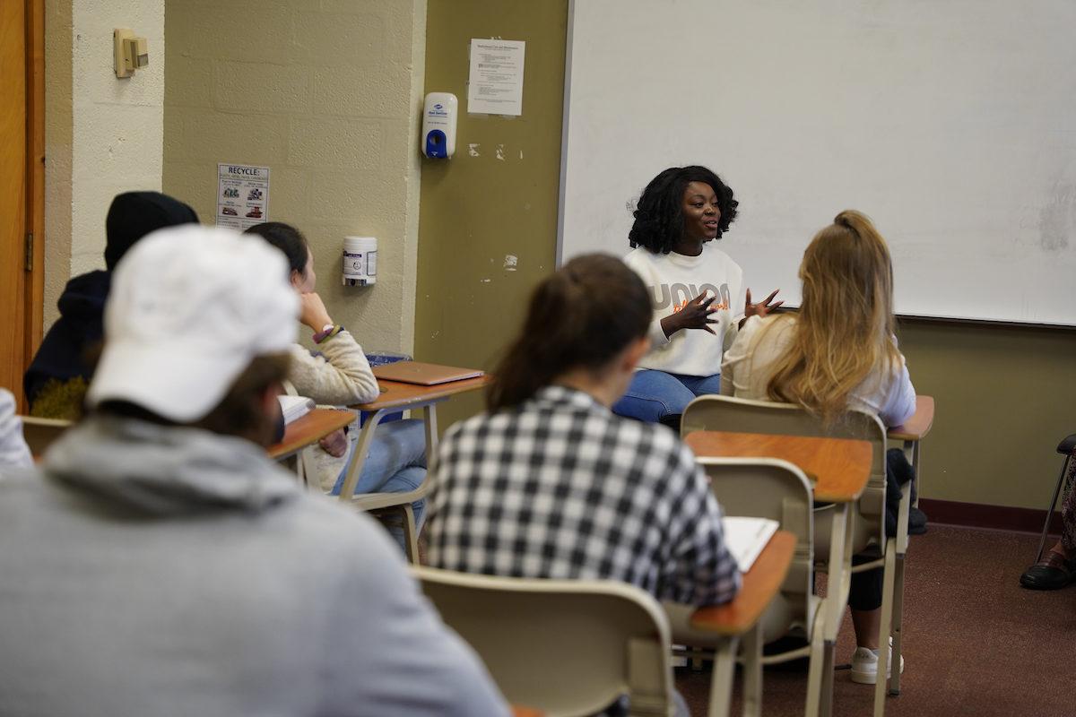 Afua Osei speaks in a classroom with students.