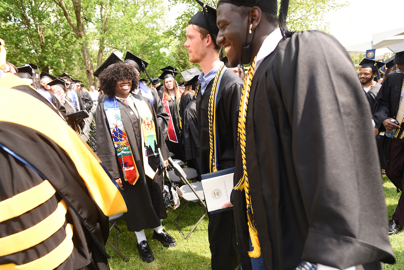graduates smile following their commencement ceremony