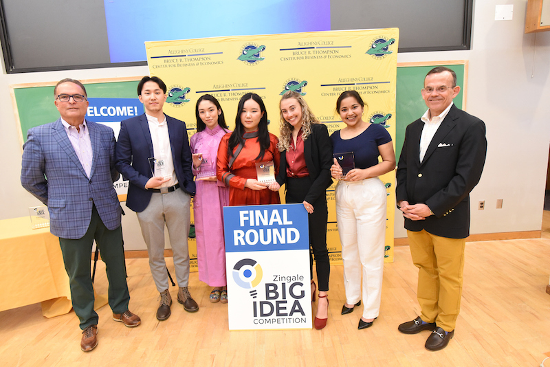 seven people post in front of a sign reading "Final Round, Zingale Big Idea Competition"