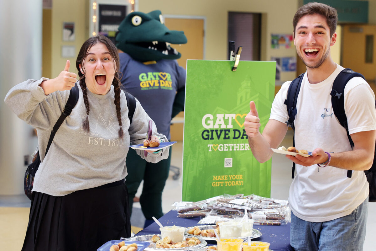 Two students with a thumbs up during Gator Give Day